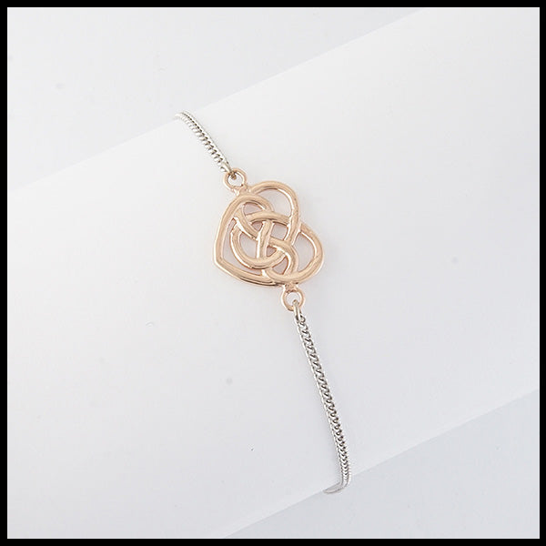 Robin's Heart bracelet features a 14K Rose gold heart on a 14K white gold chain. The Heart intertwines with an eternity knot in the center symbolizing eternal love. 