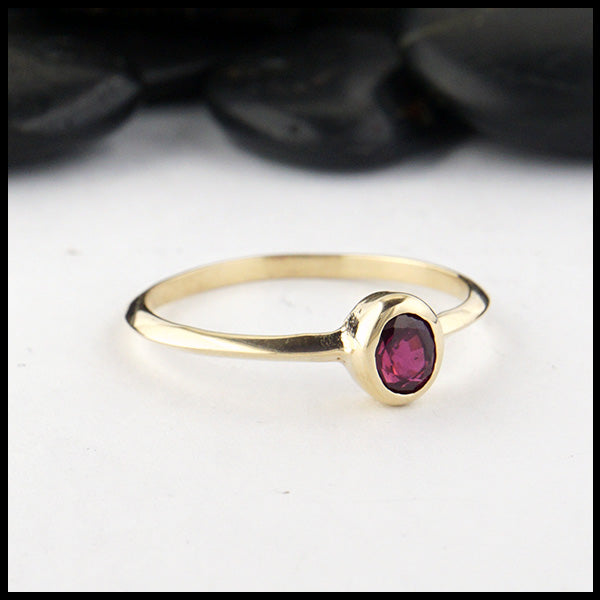 Simple 14K Yellow Gold ring bezel set with a 0.47ct 5x4mm oval Ruby.
