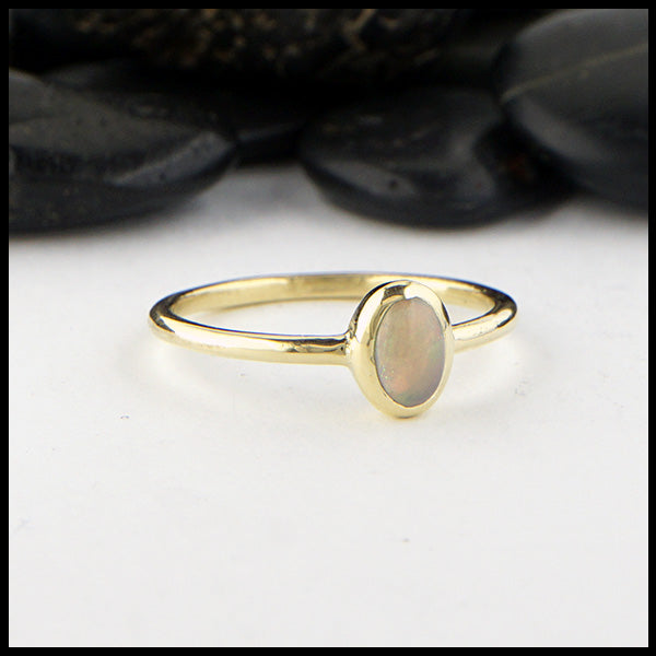 Simple 18K Yellow Gold ring bezel set with a 0.36ct oval opal.