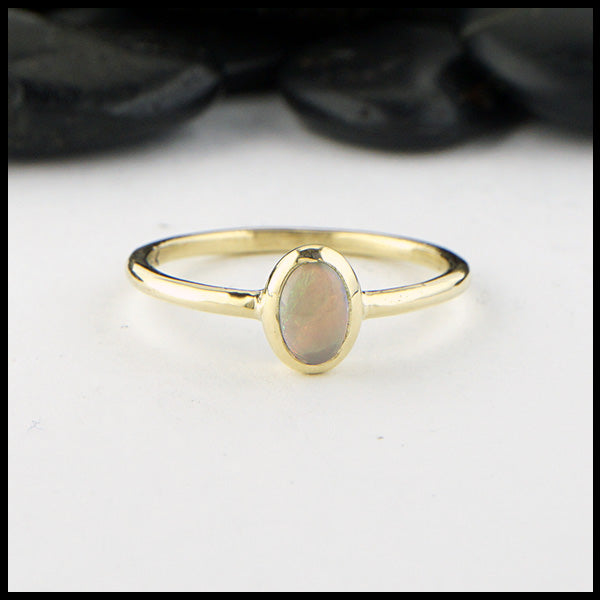 Simple 18K Yellow Gold ring bezel set with a 0.36ct oval opal.